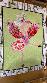 Art quit with flowery flamingo kicking up one leg